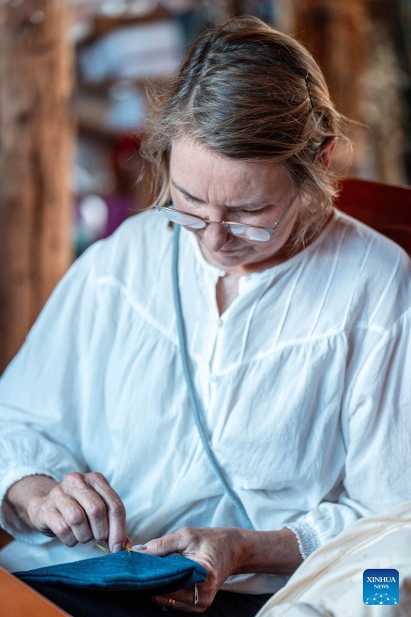 A foreign tourist experiences traditional embroidery of the Naxi ethnic group at Baisha ancient town in Lijiang, southwest China's Yunnan Province, June 17, 2026. In recent years, Baisha ancient town has drawn on its historical legacy and rich ethnic cultural resources to advance the preservation, transmission and innovative development of the embroidery of the Naxi ethnic group, injecting new vitality into the ancient craft. Photo: Xinhua