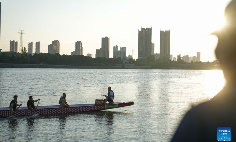 Liao Kangni (1st L) and his father Liao Hongbo (2nd L) row a dragon boat on the Miluo River, central China's Hunan Province, June 9, 2026, as his grandfather Liao Minming (1st R) watches from the riverside. 25-year-old Liao Kangni is a new recruit for the local dragon boat team, but dragon boat racing has been passed down in his family for four generations. Having grown up to the beat of dragon boat drums by the river, Liao finally got the chance to paddle in the race. (Xinhua/Xue Yuge)


