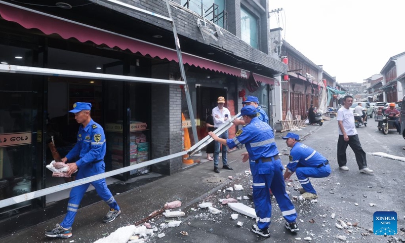 Emergency workers remove an iron signboard frame blown down by strong winds in Yuhuan of Taizhou City, east China's Zhejiang Province, July 12, 2026.