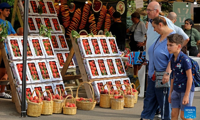 This photo taken on July 11, 2026 shows people attending a peach festival in the village of Bikfaya, Mount Lebanon, Lebanon. (Xinhua/Bilal Jawich)