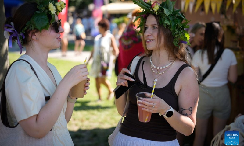 People participate in the Wianki Festival celebration in Warsaw, Poland, June 20, 2026. The event is an important Polish folk celebration of the summer solstice, during which people carry on ancient customs with wreaths, music and riverside gatherings. (Photo by Jaap Arriens/Xinhua)


