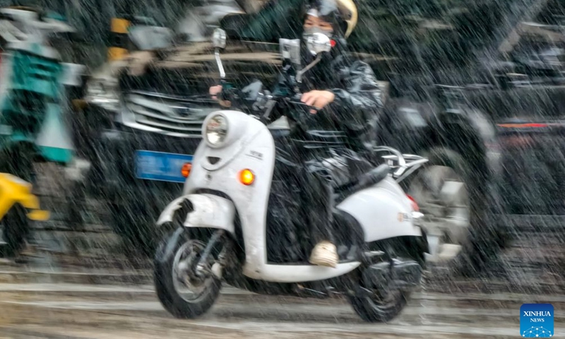 A resident rides a scooter in the rain in Xixiangtang District of Nanning, south China's Guangxi Zhuang Autonomous Region, July 5, 2026. Influenced by Typhoon Maysak, heavy to torrential rains have battered parts of southern Guangxi, with some areas experiencing extreme downpours. (Photo by Yu Xiangquan/Xinhua)