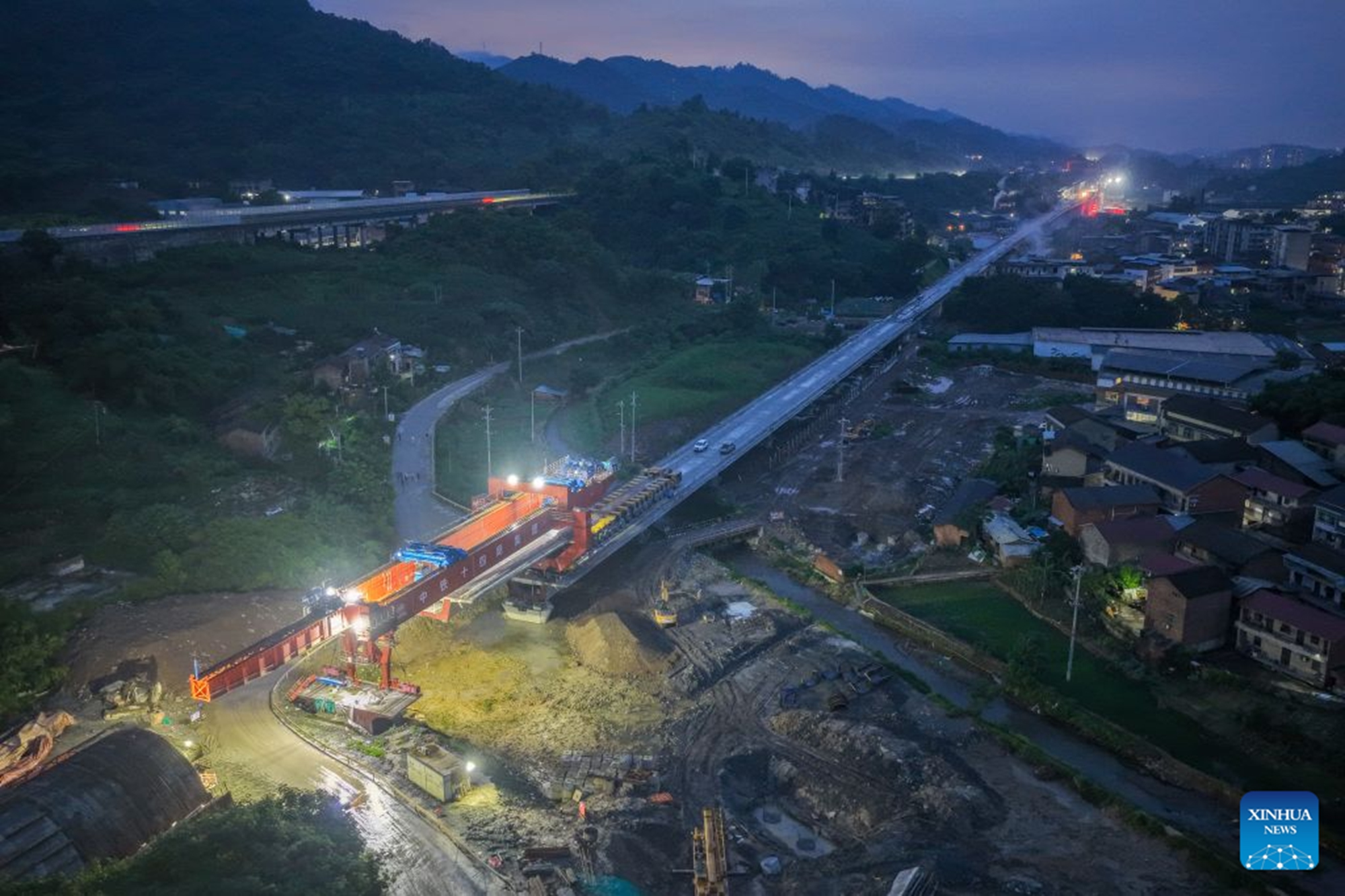 An aerial drone photo taken on June 28, 2026 shows the construction site of the Hechuan East Station grand bridge along the Xi'an-Chongqing High-speed Railway in southwest China's Chongqing Municipality. A 32-meter-long, approximately 700-tonne box girder was installed on the Hechuan East Station grand bridge on Monday, marking the completion of the box girder erection work on the Chongqing section of the Xi'an-Chongqing High-speed Railway. (Xinhua/Tang Yi)

