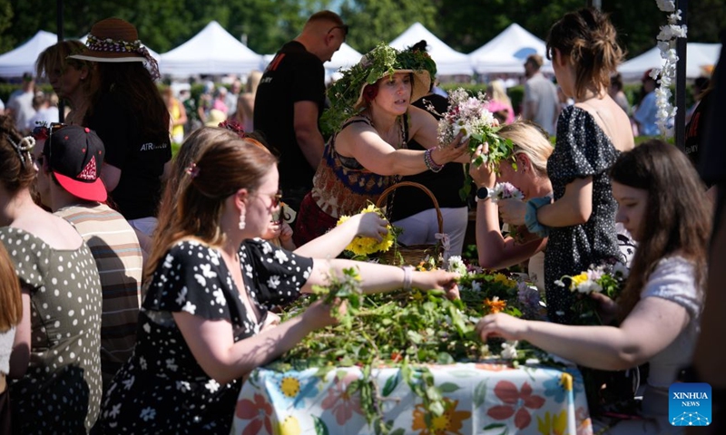 People participate in the Wianki Festival celebration in Warsaw, Poland, June 20, 2026. The event is an important Polish folk celebration of the summer solstice, during which people carry on ancient customs with wreaths, music and riverside gatherings. (Photo by Jaap Arriens/Xinhua)

