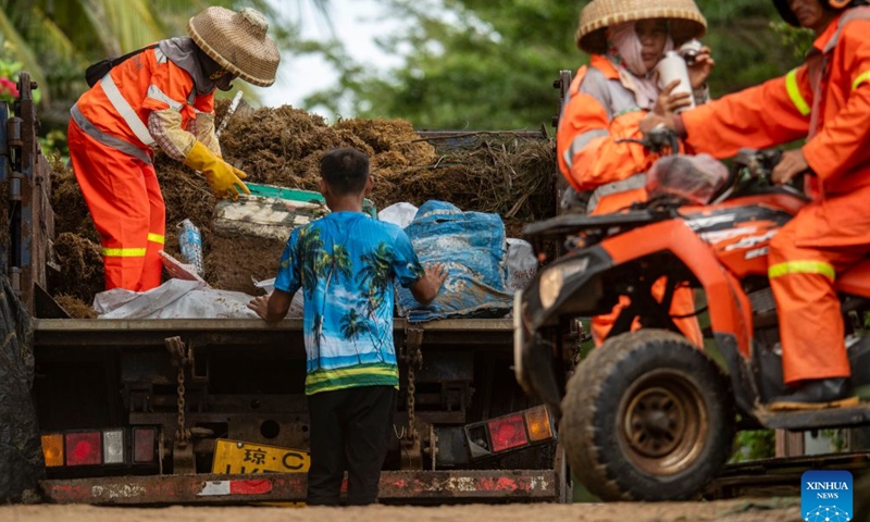 Sanitation workers transport collected debris and garbage washed ashore during a tropical storm landfall in Boao of Qionghai City, south China's Hainan Province, July 4, 2026. The tropical storm came ashore at around 6:20 p.m. in Yelin Township of Lingshui Li Autonomous County, according to the Hainan provincial meteorological bureau. At landfall, it packed maximum winds of 23 meters per second near its center. (Photo by Meng Zhongde/Xinhua)