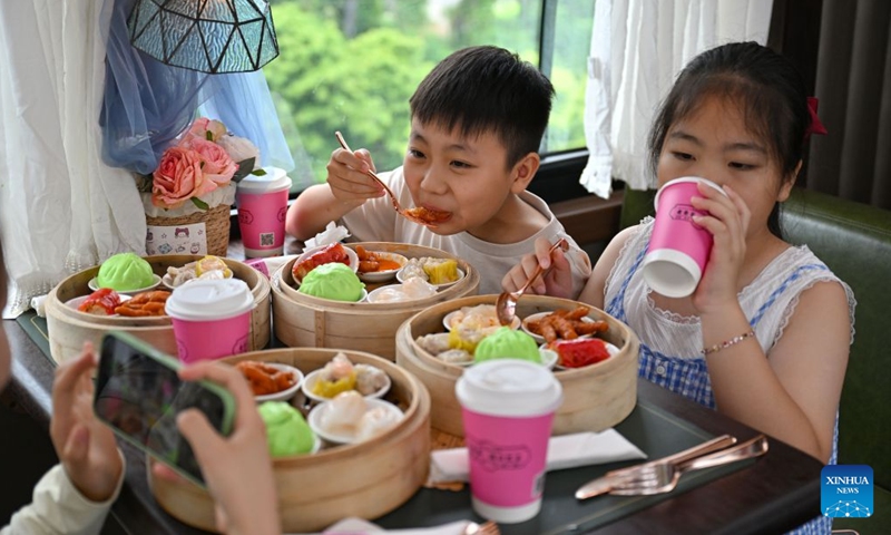 Tourists enjoy dishes aboard a Laobacha Haikou Bus in Haikou, south China's Hainan Province, July 5, 2026.
Laobacha, or literally old dad tea, refers to a teahouse culture endemic to the island province of Hainan. Offering an array of teas, pastries, and dim sum, Laobacha is a byword for the islanders' relaxed pace of life. (Xinhua/Guo Cheng)