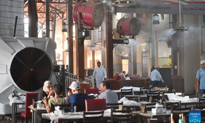 Water mist sprays are seen in a restaurant at the old market in Kuwait City, Kuwait, July 11, 2026. (Photo by Asad/Xinhua)

