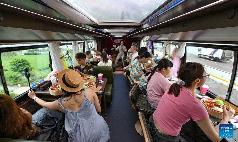 Tourists enjoy dishes aboard a Laobacha Haikou Bus in Haikou, south China's Hainan Province, July 5, 2026.
Laobacha, or literally old dad tea, refers to a teahouse culture endemic to the island province of Hainan. Offering an array of teas, pastries, and dim sum, Laobacha is a byword for the islanders' relaxed pace of life. (Xinhua/Guo Cheng)