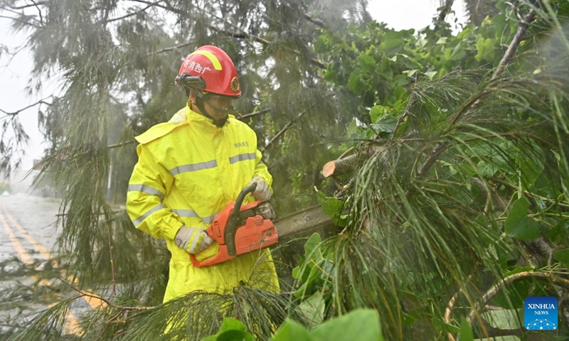 A staff member clears up a fallen tree in Jiangping Town, Dongxing of Fangchenggang, south China's Guangxi Zhuang Autonomous Region, July 4, 2026. Typhoon Maysak, the 10th typhoon of the year, made a second landfall on Saturday night along the coast near the border between Guangxi and northern Vietnam. (Xinhua/Lu Boan)