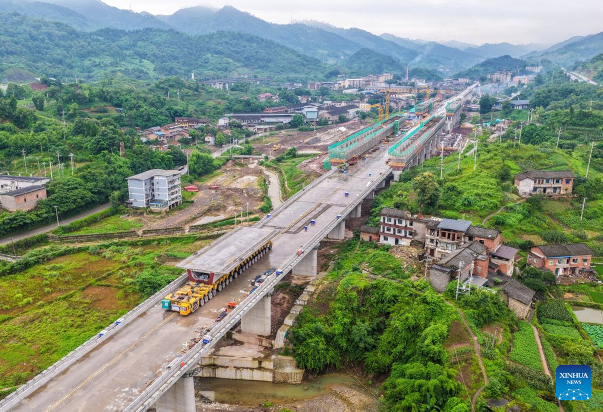 An aerial drone photo taken on June 28, 2026 shows the construction site of the Hechuan East Station grand bridge along the Xi'an-Chongqing High-speed Railway in southwest China's Chongqing Municipality. A 32-meter-long, approximately 700-tonne box girder was installed on the Hechuan East Station grand bridge on Monday, marking the completion of the box girder erection work on the Chongqing section of the Xi'an-Chongqing High-speed Railway. (Xinhua/Tang Yi)

