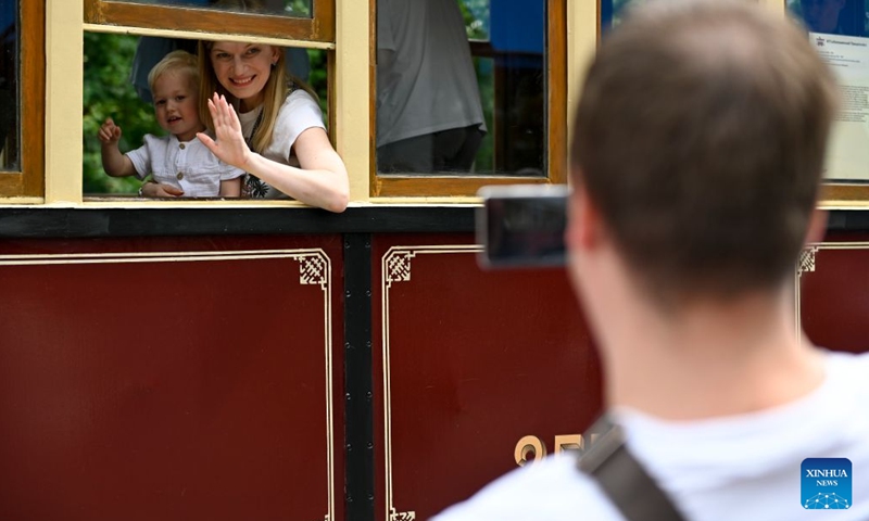 Visitors pose for photos inside a retro tram in Moscow, Russia, July 11, 2026. A retro tram parade and a vintage vehicle exhibition were held on Saturday to celebrate the Moscow Transport Day, which falls on the second Saturday of July each year. (Photo by Alexander Zemlianichenko Jr/Xinhua)