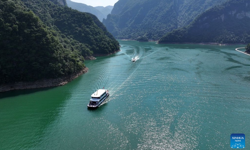 An aerial drone photo taken on June 27, 2026 shows people taking sightseeing ferries at a scenic spot in Changyang Tujia Autonomous County in Yichang, central China's Hubei Province. Hubei, dubbed the province of a thousand of lakes, has done a lot of work in the comprehensive management of its rivers and lakes, in an effort to improve its water ecology and water environment. (Photo by Zhao Jun/Xinhua)

