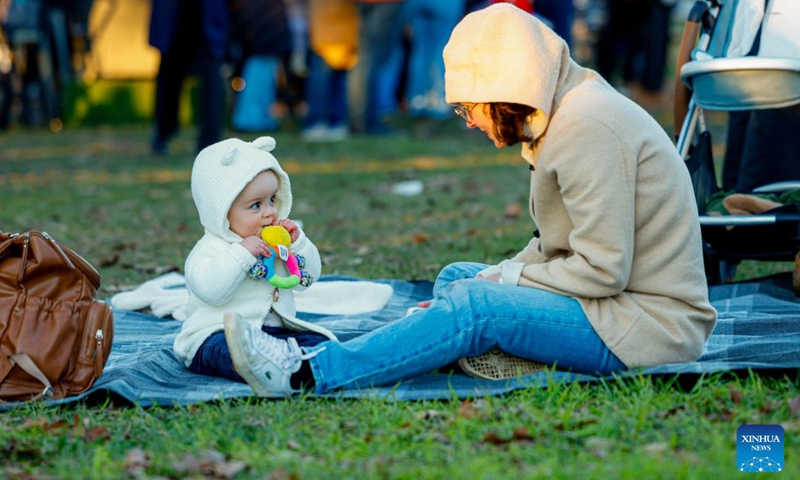 A mother and her child enjoy themselves during the July Christmas event in Canberra, Australia, July 4, 2026. July Christmas stems from Australians' longing for a traditional white Christmas in the Southern Hemisphere. (Photo by Chu Chen/Xinhua)