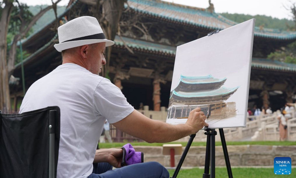 A Hungarian artist paints next to an ancient building in Taiyuan City, north China's Shanxi Province, June 18, 2026. A total of 23 artists, art educators, students and cultural professionals from Hungary wrapped up their discovery tour of the ancient architectural heritages in north China's Shanxi Province on Sunday. (Xinhua/Chen Zhihao)

