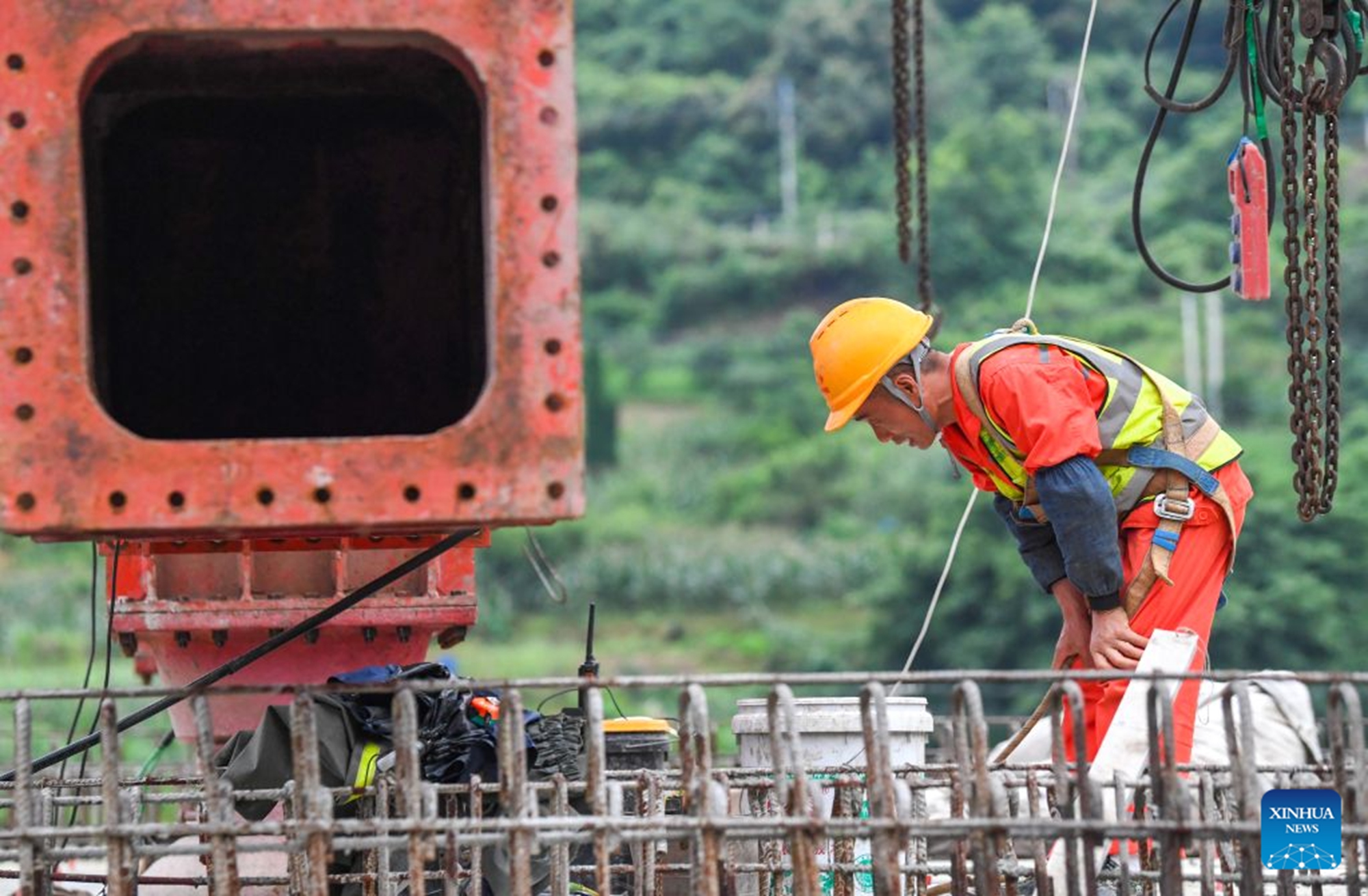 A worker conducts box girder erection work at the construction site of the Hechuan East Station grand bridge along the Xi'an-Chongqing High-speed Railway in southwest China's Chongqing Municipality, June 28, 2026. A 32-meter-long, approximately 700-tonne box girder was installed on the Hechuan East Station grand bridge on Monday, marking the completion of the box girder erection work on the Chongqing section of the Xi'an-Chongqing High-speed Railway. (Xinhua/Tang Yi)



