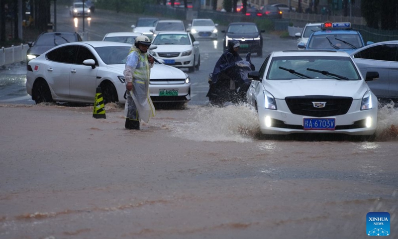 A traffic police directs traffic in a waterlogged road section in Nanning, south China's Guangxi Zhuang Autonomous Region, July 5, 2026. Influenced by Typhoon Maysak, heavy to torrential rains have battered parts of southern Guangxi, with some areas experiencing extreme downpours. (Xinhua/Zhou Hua)