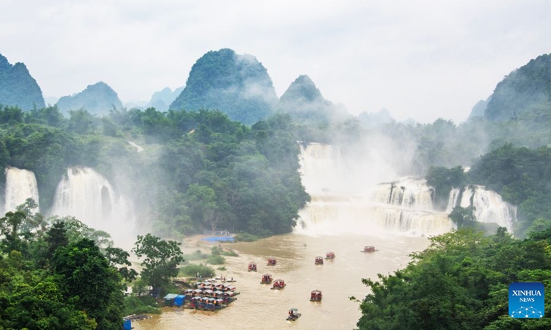 Tourists take rafts for sightseeing in Daxin County of Chongzuo City, south China's Guangxi Zhuang Autonomous Region, June 20, 2026. People enjoyed the three-day holiday of the Dragon Boat Festival, also called Duanwu Festival, which falls on June 19 this year, via various activities across the country. (Photo by Zhao Jingwu/Xinhua)