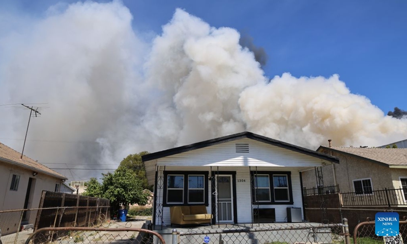 Heavy smoke pours out from a facility where a fire has erupted in Boyle Heights, Los Angeles, California of the United States, on June 20, 2026. Mayor Karen Bass of the U.S. city of Los Angeles on Saturday declared a local emergency in response to an ongoing warehouse fire that erupted Wednesday and generated heavy smoke, which has spread across the Los Angeles metropolitan area for several days. (Photo by Zeng Hui/Xinhua)

