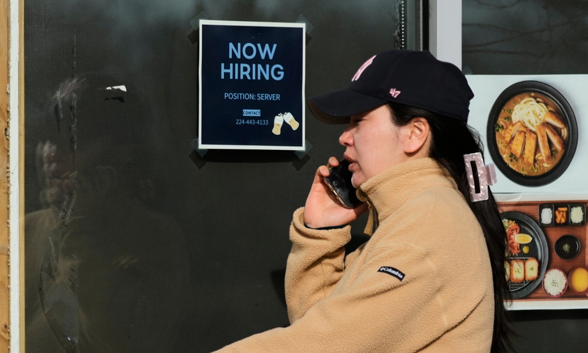 A pedestrian walks past a hiring sign displayed outside a restaurant in Illinois, the US, on April 7, 2026. Photo: VCG