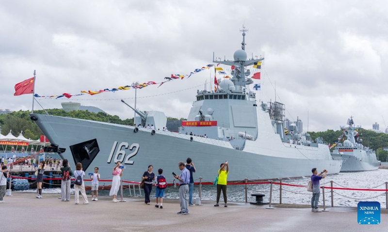 People take photos in front of the guided-missile destroyer Nanning at the Chinese People's Liberation Army (PLA) Hong Kong Garrison's naval base on Stonecutters Island in south China's Hong Kong, July 4, 2026. A Chinese People's Liberation Army (PLA) Navy fleet opens to Hong Kong and Macao residents and students from Friday through Sunday.