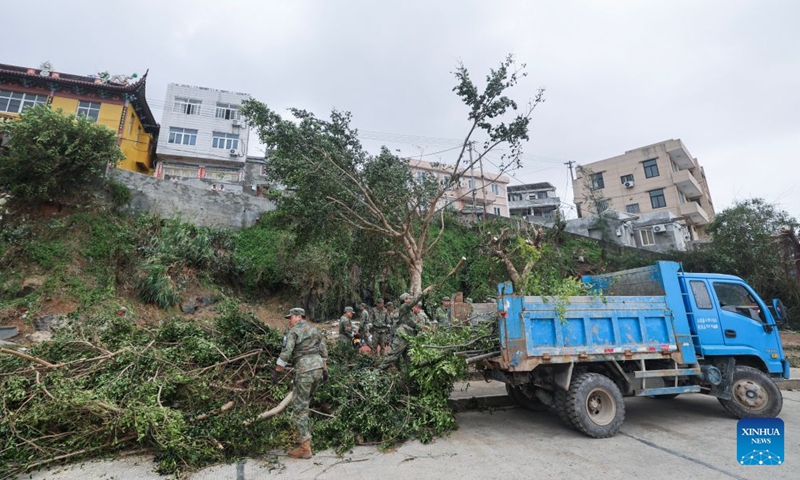 Soldiers clear branches blown down by strong winds at a community in Yuhuan of Taizhou City, east China's Zhejiang Province, July 12, 2026.