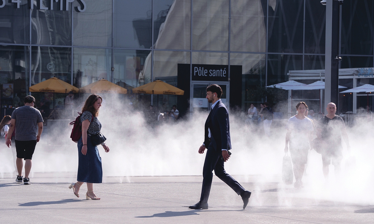Workers cool themselves in water misters during high temperatures in the La Defense business district of Paris, France, on May 28, 2026. Photo: VCG