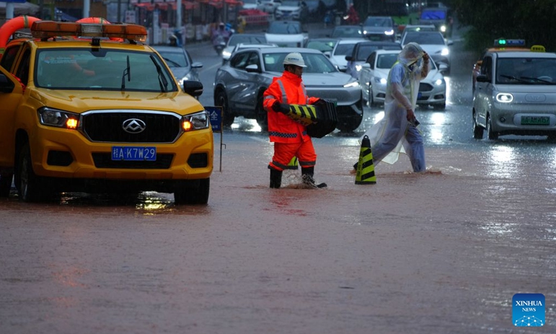 A staff member sets up warning signs in a waterlogged road section in Nanning, south China's Guangxi Zhuang Autonomous Region, July 5, 2026. Influenced by Typhoon Maysak, heavy to torrential rains have battered parts of southern Guangxi, with some areas experiencing extreme downpours. (Xinhua/Zhou Hua)