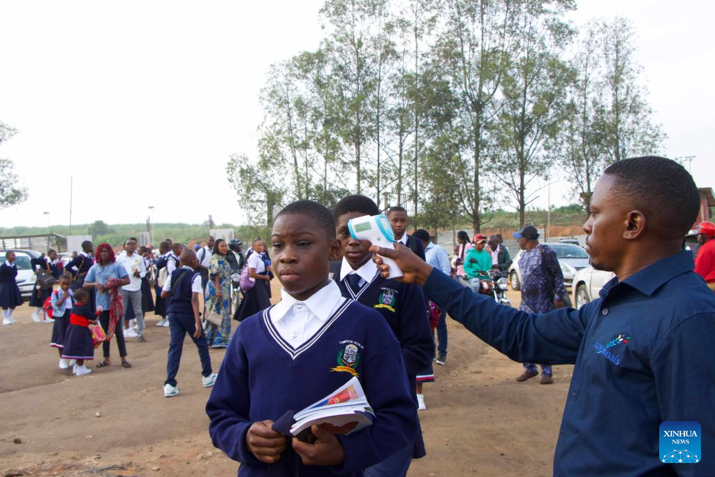 A teacher checks students' temperatures at a school in Bunia, Ituri Province, the Democratic Republic of the Congo (DRC), Sept. 1, 2026. (Xinhua)