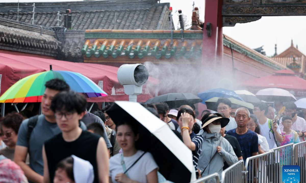 Tourists line up in front of a water-misting machine outside Shenyang Palace Museum in Shenyang, northeast China's Liaoning Province, July 30, 2026. (Xinhua/Li Gang)