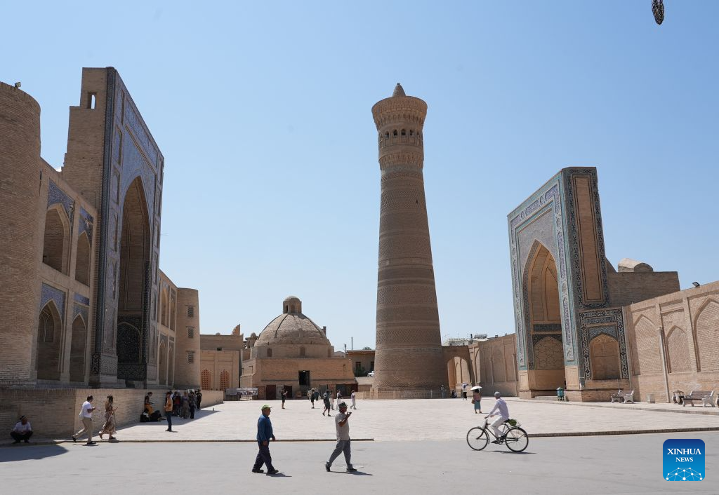 People walk across the Po-i-Kalyan Complex in Bukhara, Uzbekistan, Aug. 3, 2026. The historic city of Bukhara in southwestern Uzbekistan is currently gripping with severe heat, with daytime highs consecutively exceeding 35 degrees Celsius. (Photo by Zafar Khalilov/Xinhua)