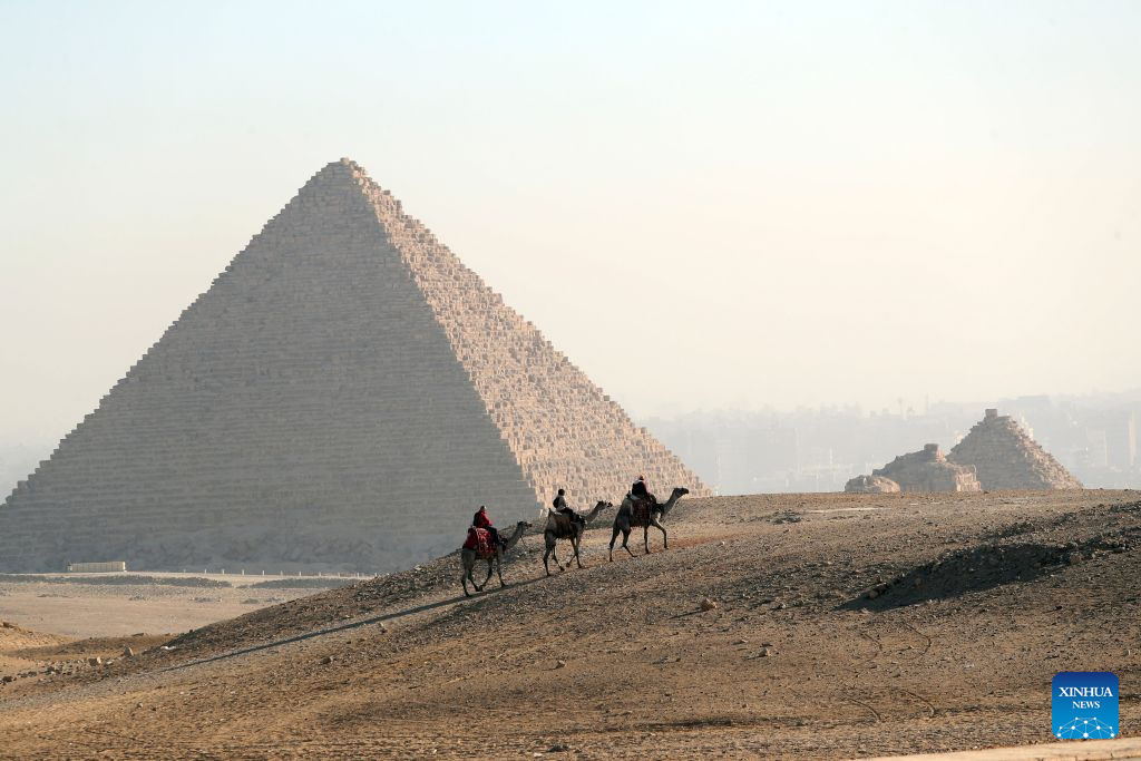 Tourists ride camels at the Pyramids scenic spot in Giza, Egypt, Aug. 16, 2026. (Xinhua/Ahmed Gomaa)