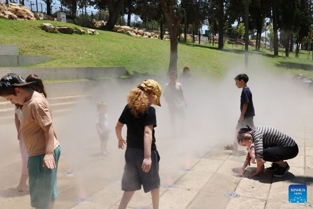 People cool off during a heatwave at a park in Jerusalem, Aug. 2, 2026. A severe heatwave has swept across Jerusalem in recent days. (Photo by Gil Cohen Magen/Xinhua)
