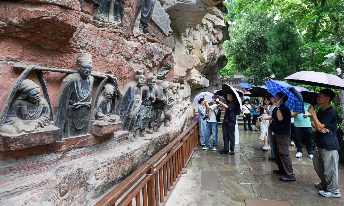 Journalists from cross-Straits media outlets visit the Dazu Rock Carvings scenic area in Southwest China's Chongqing Municipality on June 23, 2026. The carvings here date from the 9th to 13th centuries and were placed on the World Heritage List by the UNESCO in 1999. Photo: VCG