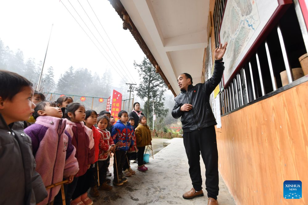 Pan Xianfeng (R) and Peng Hanping (back) teach students at the Wuying teaching site in Wuying Village on the border between south China's Guangxi Zhuang Autonomous Region and southwest China's Guizhou Province, March 15, 2024. (Xinhua/Huang Xiaobang)