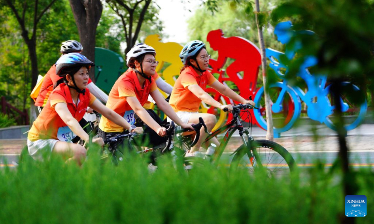 Cycling enthusiasts ride in Xingtai City, north China's Hebei Province, July 22, 2026. Xingtai City is a nationally renowned bicycle manufacturing base, with its products sold worldwide. In recent years, Xingtai has pushed forward the upgrading of the bicycle industry, continuously improved cycling infrastructure, and hosted a wide range of professional cycling races and mass public riding events. By integrating manufacturing and cycling events, the city has fueled accelerated growth of the local bicycle sector. (Photo by Feng Yichao/Xinhua)