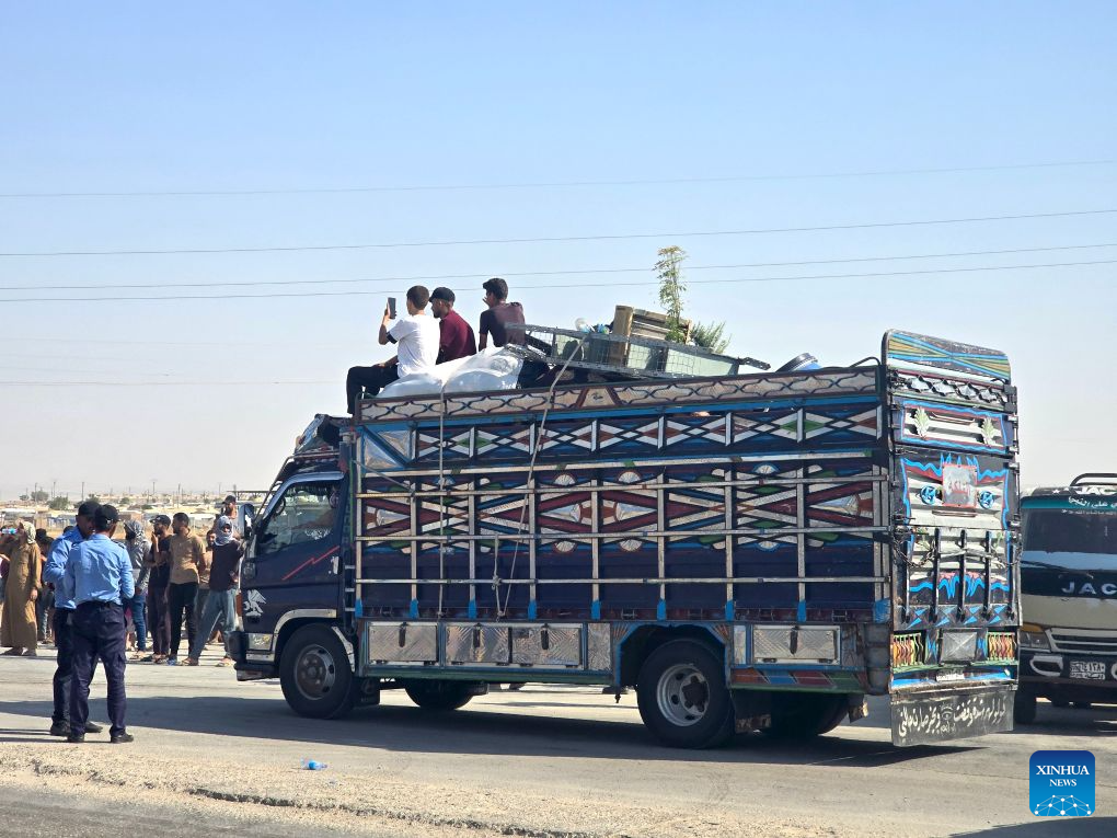 Displaced Syrians travel with their belongings aboard a truck as a convoy heads toward the city of Ras al-Ain and its surrounding villages in Hasakah province, northeastern Syria, Aug. 10, 2026. More than 400 Syrian families returned to the city of Ras al-Ain in northeastern Hasakah province and its surrounding villages on Monday, marking the first organized convoy of displaced residents heading home in that area after nearly seven years of displacement. (Str/Xinhua)