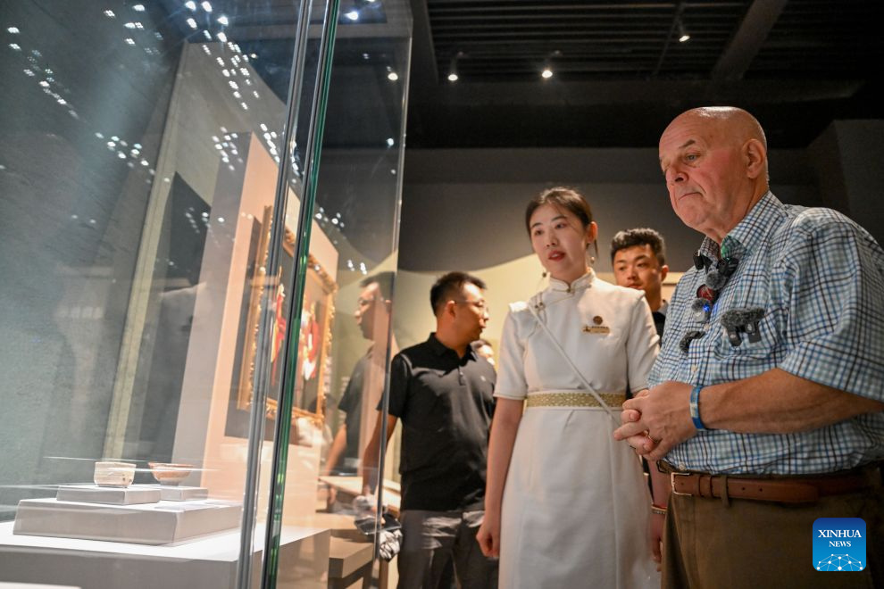 Ronald Sakolsky (1st R) visits the Inner Mongolia Museum in Hohhot, north China's Inner Mongolia Autonomous Region, Aug. 26, 2026.
Ronald Sakolsky, accompanied by Yin Yuzhen, a national model worker, visited Hohhot in Inner Mongolia on Wednesday.
Yin has spent four decades planting trees across northern China's Maowusu Sandy Land, the country's fourth-largest sandy area. Her life-changing cross-border friendship dates back to 1999. That year, Sakolsky watched a TV report covering Yin's arduous sand-control work while teaching in China. Deeply moved, he raised 5,000 U.S. dollars to fund her afforestation work.
The donation enabled Yin to purchase and plant more than 50,000 saplings. Those saplings have since grown into a sprawling forest, turning barren dunes into thriving green space. Earlier this year, Yin reconnected online with her long-lost American friend, who traveled to China on Sunday to revisit the forest he helped create and meet Yin in person. (Xinhua/Lian Zhen)
