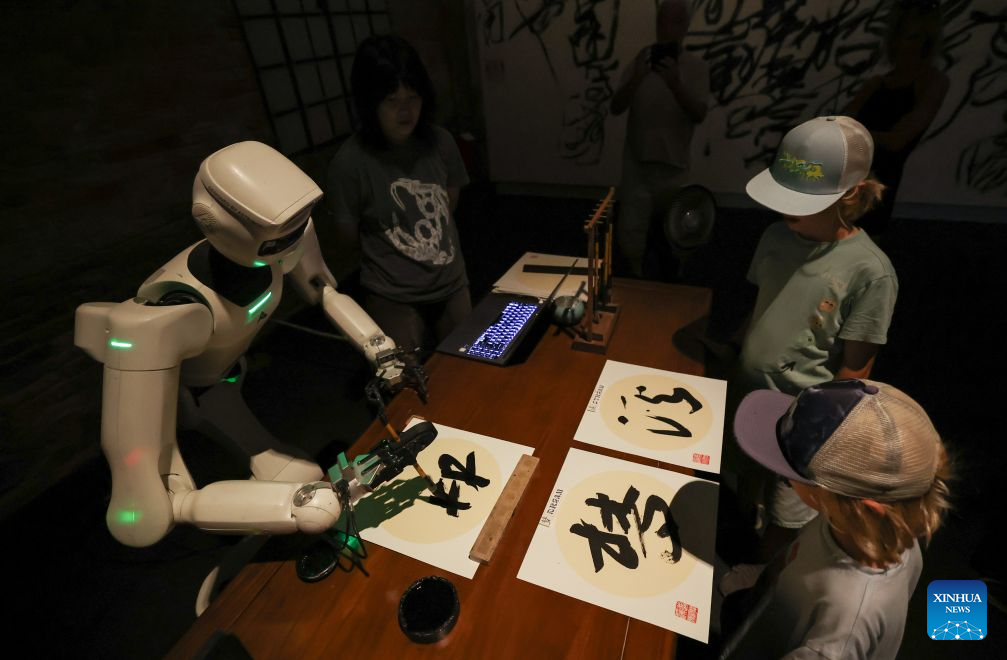 Visitors watch the robotic calligraphy at the China pavilion themed Dream Stream of the 61st International Art Exhibition of La Biennale di Venezia in Venice, Italy, Sept. 1, 2026. (Xinhua/Wang Kaiyan)