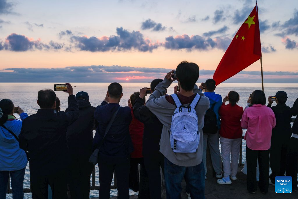People capture sea views at sunrise in Rongcheng, east China's Shandong Province, Oct. 10, 2026. (Xinhua/Chen Yehua)