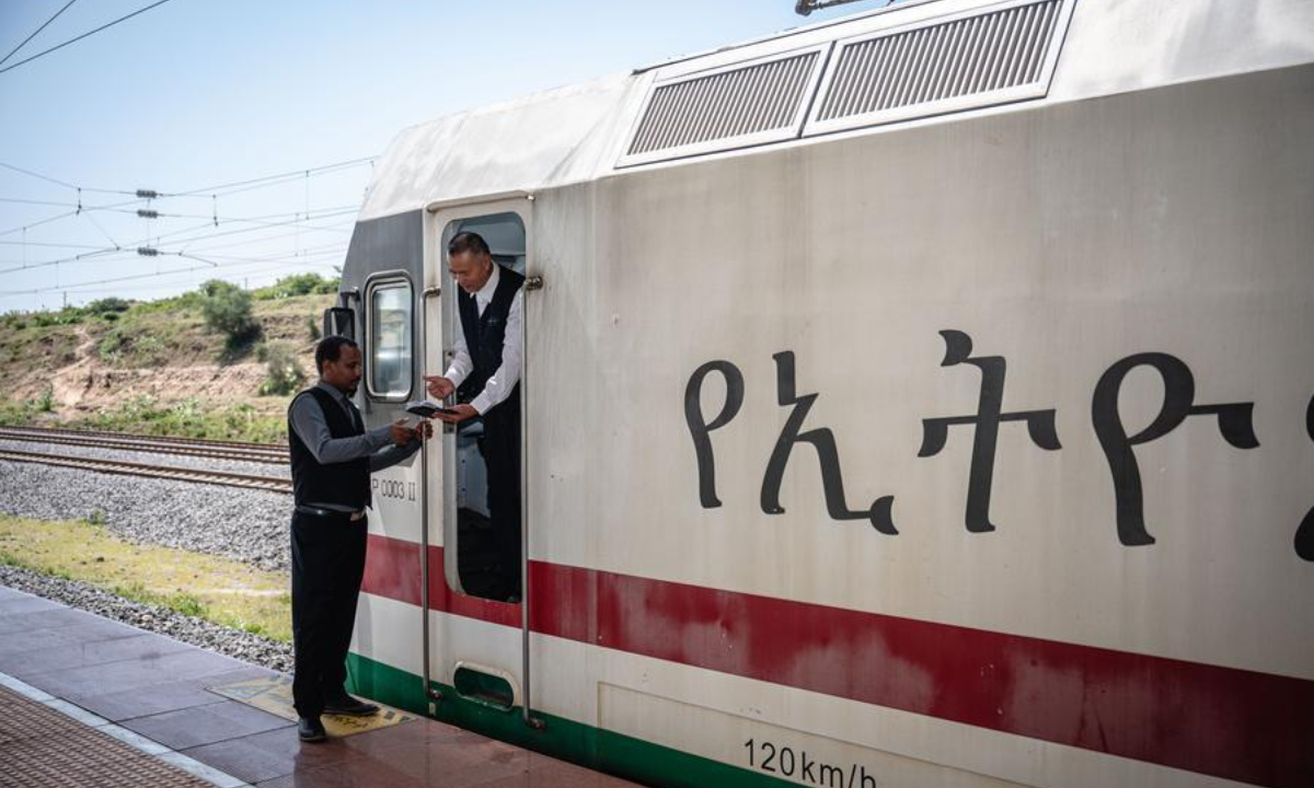 A local train driver receivs a notebook from his Chinese predecessor at the Adama station in Adama City, Ethiopia, Sept. 9, 2023. (Xinhua/Wang Guansen)
