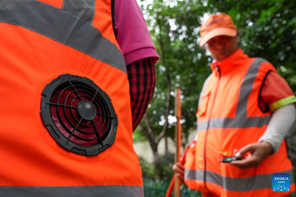 Sanitation workers in cooling vests are seen in Nanjing, east China's Jiangsu Province, July 28, 2026. Recently, in response to the high summer temperatures, sanitation workers in Xuanwu District of Nanjing City have been equipped with cooling vests. The vests are fitted with miniature fans on both sides of the waist, providing inward airflow. (Xinhua/Li Bo)