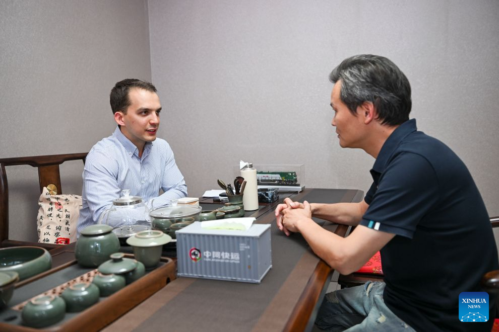 Arseniy Kretov talks with his client at an office in Urumqi, northwest China's Xinjiang Uygur Autonomous Region, Sept. 2, 2026. (Xinhua/Hu Huhu)