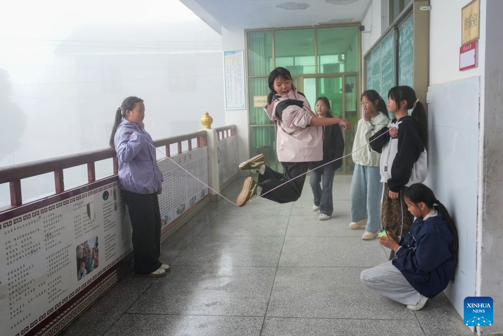 Students play during the recess at Caoyuan school in Caoyuan Village of Longhui County, central China's Hunan Province, Sept. 3, 2026.
In 2017, during a visit to her alma mater, Caoyuan school, Tan Meizhen learned that declining student numbers and a teacher shortage were pushing the school toward closure. Local children would have to attend other schools farther away.
At the time, Tan was teaching at another primary school in the town seat, but she decided to return to Caoyuan school.
After Tan returned, she was the only remaining teacher, and the school facilities were in poor condition. She rented a villager's house as a classroom and painted the door black to use as a blackboard. Despite numerous challenges, Tan remained committed to addressing the issues.
In 2018, three graduates from Hunan University volunteered to teach at the school, followed by additional batches of volunteer students.
With support from the local government, the school built a new teaching building with four classrooms. As teaching staff and facilities improved, students' academic performance steadily advanced. Today, Caoyuan school attracts students from some surrounding villages, with over 300 students and teachers. (Xinhua/Xue Yuge)