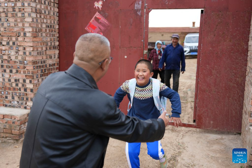 Yao Jian (1st L) picks up a student from his home in Shisangou Village, Fengzhen City, north China's Inner Mongolia Autonomous Region, Sept. 7, 2026. (Xinhua/Yang Chenguang)