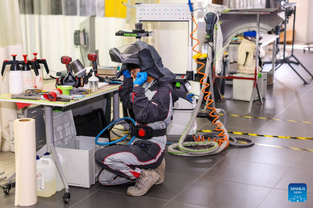 Duan Libo wears protective gear before entering the spray-painting booth at a training facility of Hangzhou Technician Institute in Hangzhou, east China's Zhejiang Province, Sept. 7, 2026. (Xinhua/Jiang Han)