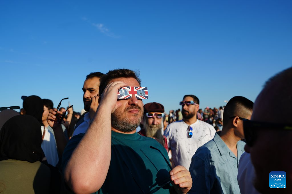 People observe the partial solar eclipse on Primrose Hill in London, Britain, Aug. 12, 2026. (Xinhua/Zhang Feng)