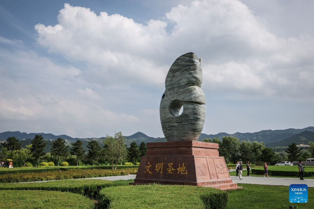 People visit the Niuheliang national archaeological relic site park in Chaoyang City, northeast China's Liaoning Province, Aug. 4, 2026. The Niuheliang national archaeological relic site park was built on the Niuheliang site, a large-scale prehistoric ritual and burial complex featuring the temple of the goddess, altars and stone tombs. Dating back more than 5,000 years, the site unearthed stone tools, pottery and jade artifacts with dragon, phoenix and human motifs, reflecting the rituals and beliefs of the Hongshan culture. (Xinhua/Pan Yulong)