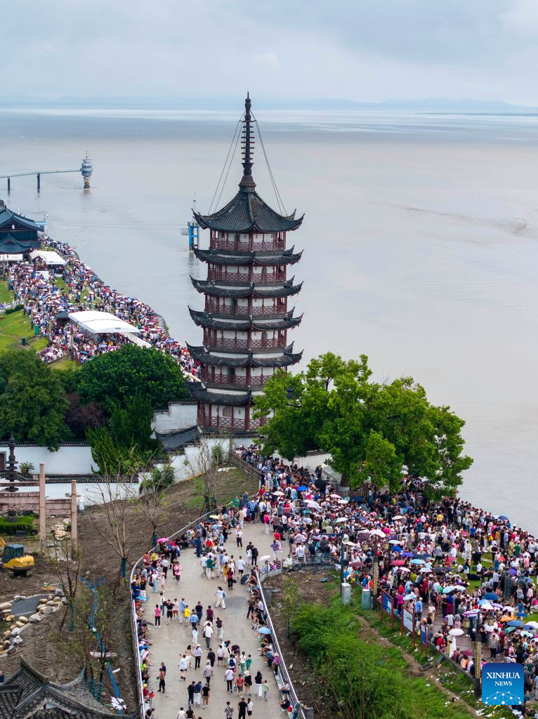 An aerial drone photo taken on Aug. 30, 2026 shows tourists waiting to view the tidal bore of the Qiantang River in Haining City, east China's Zhejiang Province. (Photo by Tang Dehong/Xinhua)