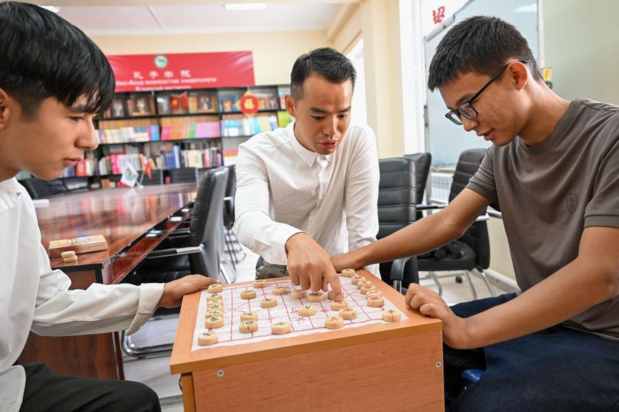 A teacher tutors students on Chinese chess during a break at the Confucius Institute at the Jalal-Abad State University in Manas City, Kyrgyzstan, Sept. 23, 2026. (Xinhua/Jiang Youlin)