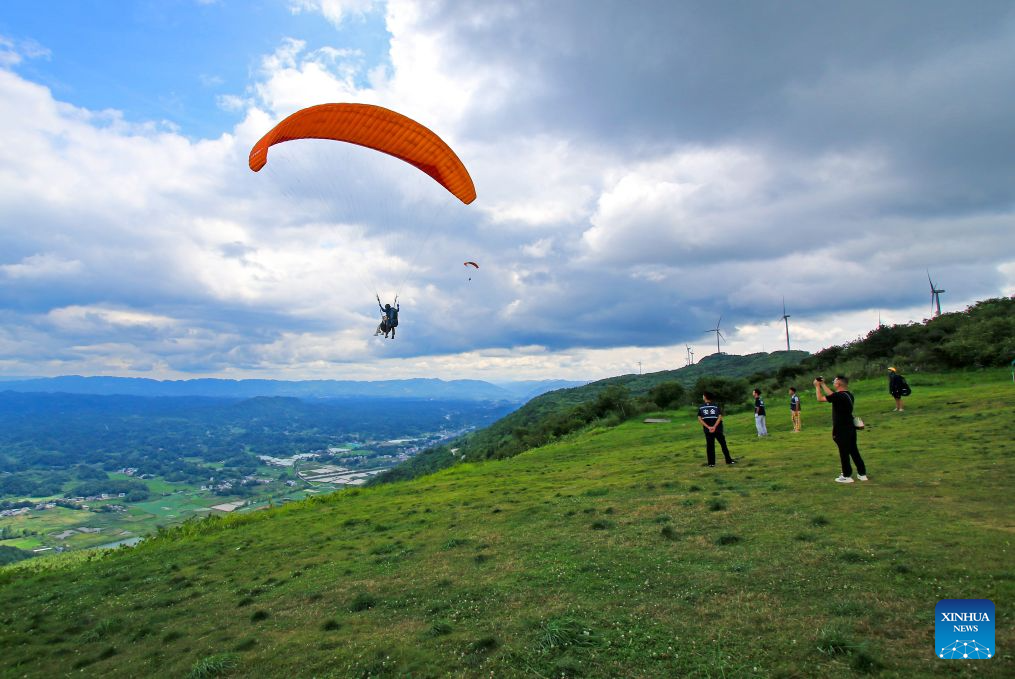 Enthusiasts experience paragliding at a paragliding base in Lichuan City, Enshi Tujia and Miao Autonomous Prefecture, central China's Hubei Province, Aug. 1, 2026. (Photo by Tan Hua/Xinhua)